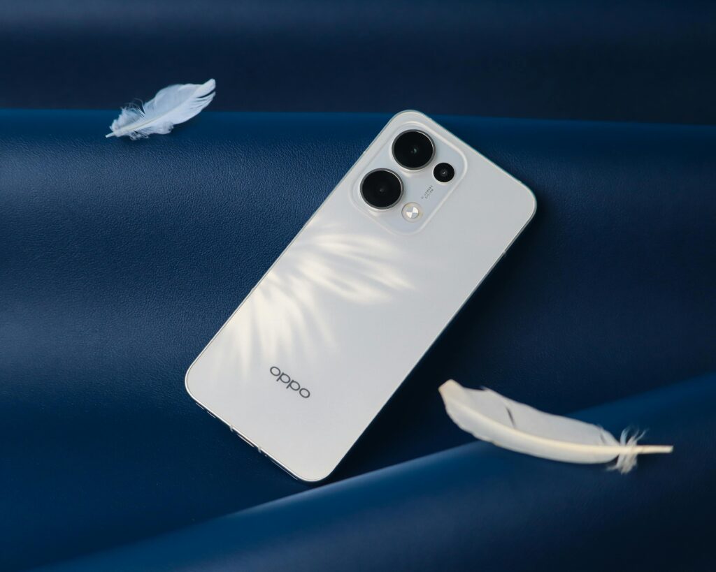 Modern white smartphone with dual camera lens on a blue background with soft feathers.